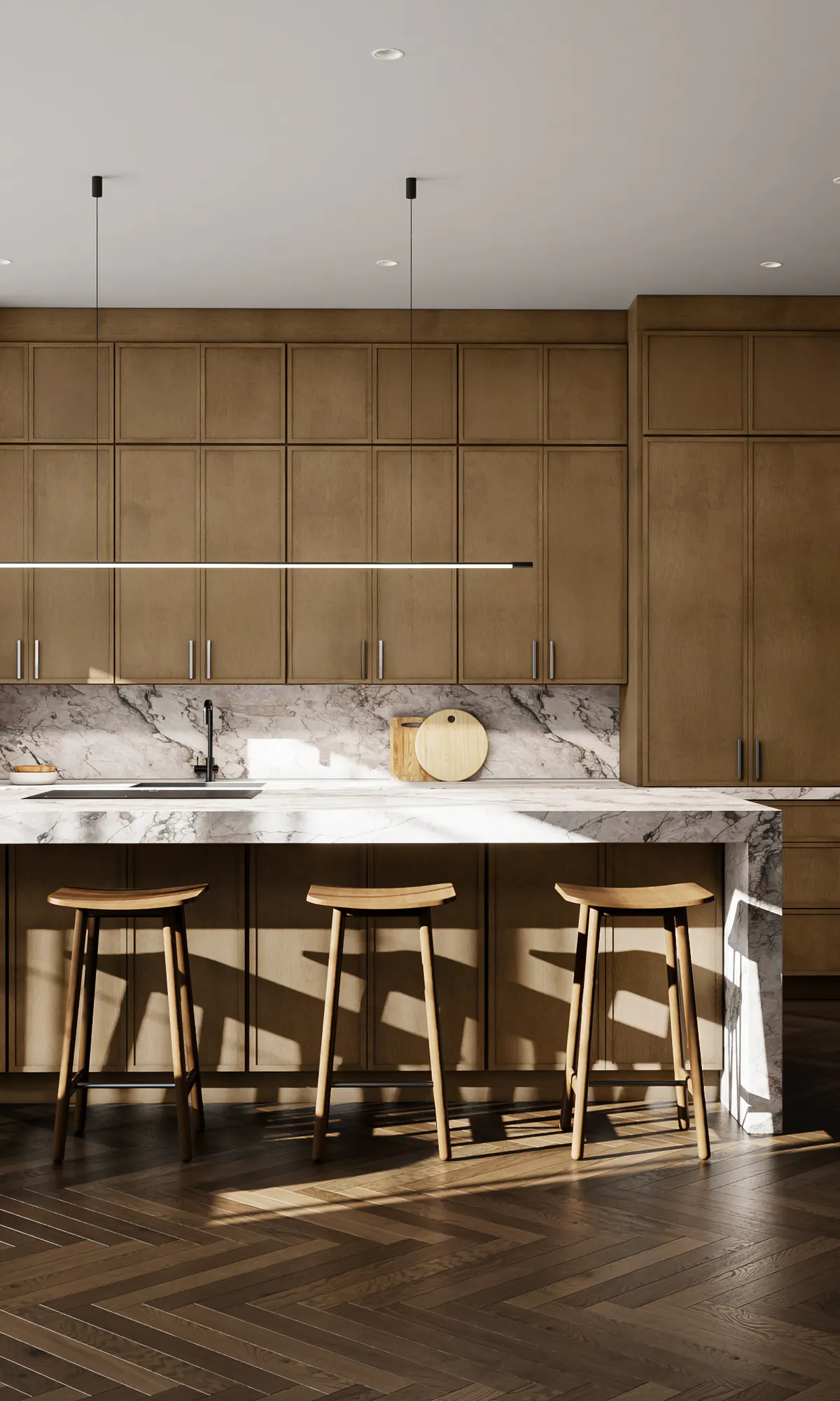 A warm wood kitchen with tall cabinets and a long stone island