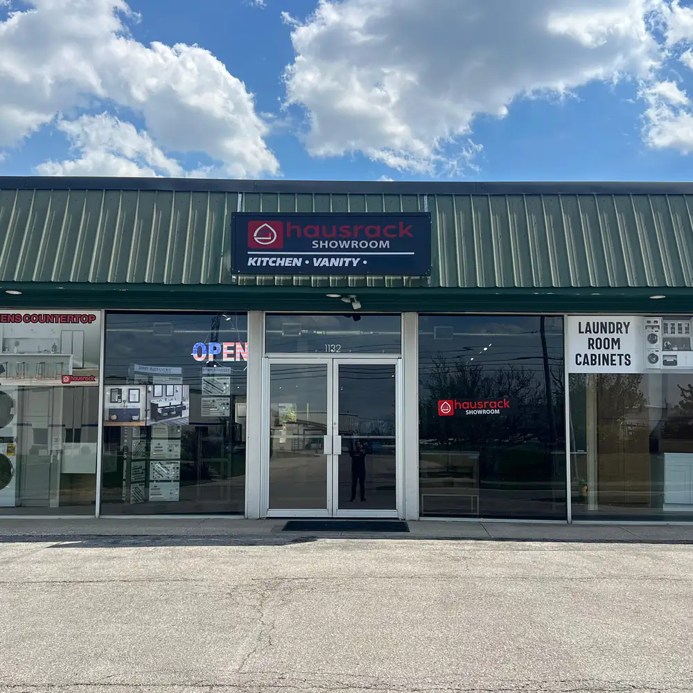 The HausRack Lexington showroom at 1132 Industry Rd: a green metal roof over glass shop windows and a lit hausrack showroom sign